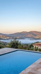 Fototapeta premium Scenic view of a tranquil pool overlooking misty mountains at sunrise.