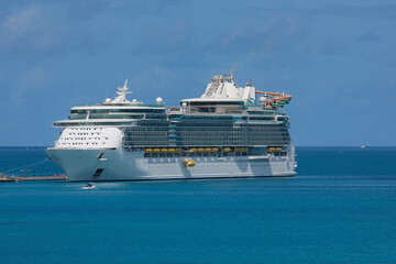 Modern refurbished mega family cruiseship cruise ship liner Liberty docked at Royal Navy Dockyard pier near Hamilton, Bermuda on sunny day with massive Aqua waterslide park on outdoor deck for kids