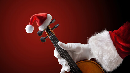 Santa Claus holding a violin  on red isolated background © Davizro Photography