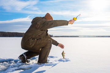  Fisherman at ice winter fishing. Ice fishing