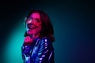 Photo of gorgeous young girl look empty space wear shiny dress neon light dark blue background