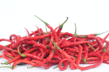 a bunch of fresh curly red chilies isolated on white background. In Indonesia, it is commonly called cabai merah keriting.