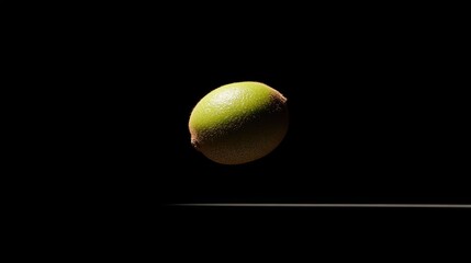 Floating lime on a dark background with ample negative space, perfect for text overlay or artistic design purposes.
