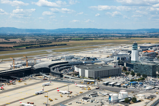 Vienna, Austria - July 29, 2024: Vienna Airport in Schwechat. Aerial view with apron, terminal building, air traffic control tower and airplanes.