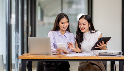 Financial Business two women analyze the graph of the company's performance to create profits and growth, Market research reports and income statistics, Financial and Accounting concept.	