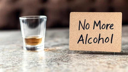 Fototapeten Cork sign next to a glass of whiskey symbolizes the choice to stop drinking alcohol © Bonsales
