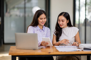 Obraz premium Financial Business two women analyze the graph of the company's performance to create profits and growth, Market research reports and income statistics, Financial and Accounting concept. 