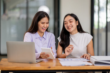 Financial Business two women analyze the graph of the company's performance to create profits and growth, Market research reports and income statistics, Financial and Accounting concept.	