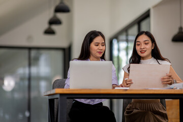 Financial Business two women analyze the graph of the company's performance to create profits and growth, Market research reports and income statistics, Financial and Accounting concept.	