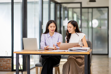 Financial Business two women analyze the graph of the company's performance to create profits and growth, Market research reports and income statistics, Financial and Accounting concept.	