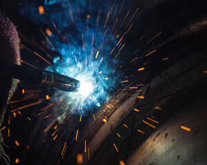worker welding with sparks in the factory