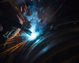 worker welding with sparks in the factory