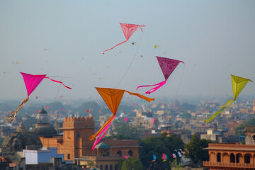 Beautiful greeting card with colorful kites soaring high above vibrant sky to holiday composition