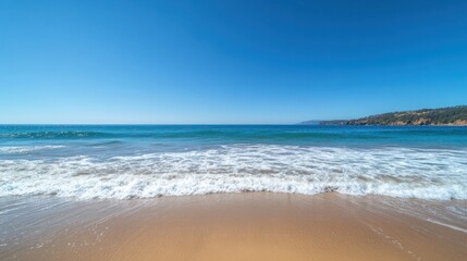 Fototapeta premium Peaceful sea with soft waves under a clear blue sky, a perfect tranquil ocean background