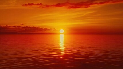 Obraz premium Sunset over the sea with fiery orange and red hues casting reflections on calm water