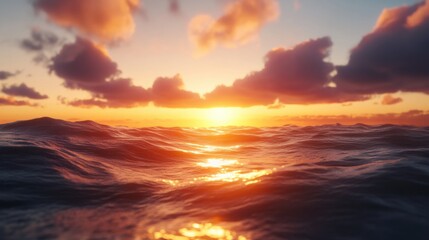 Fototapeta premium Sunset over the sea with warm light reflecting on the waves and clouds glowing in the sky
