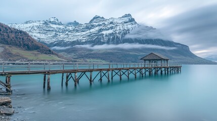 Tranquil Scene of a Wood Pier Extending into a Serene Lake Surrounded by Majestic Snow-Capped...