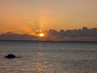 Golden Sunrise over the sea as the sun breaks through low clouds on the horizon