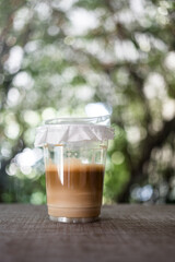 A glass of ice coffee in a plastic cup with lid cover for deliver server for customer to home or office in the morning