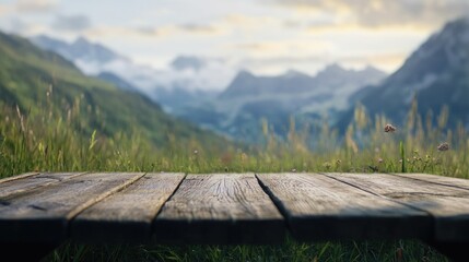 Wooden tabletop in focus with a soft-focus mountain and grass field backdrop, creating an ideal setting for product displays and design layouts.