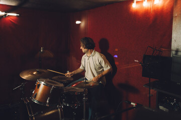 Drummer playing dynamic rhythms during a recording session