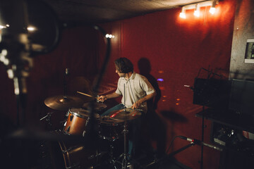 Drummer playing dynamic rhythms during a recording session