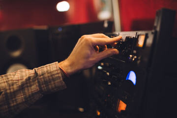 Close-up of a sound engineer adjusting audio levels on a mixer