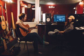 Musician preparing a song while producer listens
