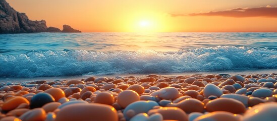Obraz premium Serene sunset over a rocky beach with vibrant pebbles and gentle waves creating a tranquil coastal atmosphere.