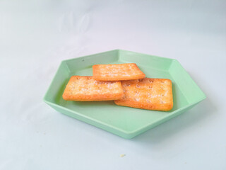 Sugar coated biscuits, also known as malkist, sweet and crispy. on a green hexagon plate isolate on white. snack concept
