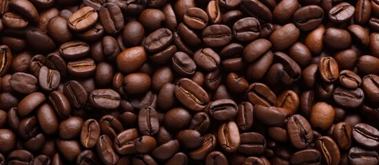 Obraz premium Rich texture of roasted coffee beans creating a seamless background for cafe and beverage design projects.