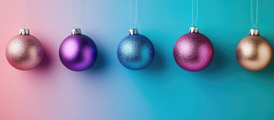 Obraz premium Colorful Christmas ornaments in a line against a gradient background for festive holiday decoration and seasonal celebrations