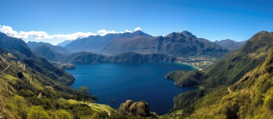 Panoramic view of serene lake surrounded by mountains near Mirador del Rio in clear blue sky showcasing breathtaking natural scenery