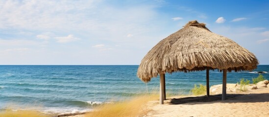 Thatched beach hut with sea view under clear skies a perfect summer seascape ideal for relaxation and travel promotion