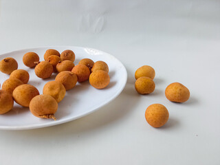 longan fruit on a white round plate isolate on white background