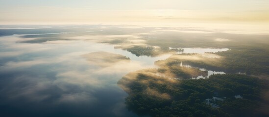 Fototapeta premium Aerial view of serene morning mist over tranquil lakes and lush landscapes in soft natural light