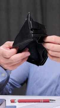vertical video concept of bankruptcy business. office worker shakes his wallet.
