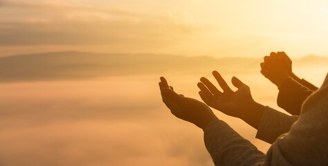 Serene embrace of nature, Christian man and woman worship Jesus Christ with hands raised in prayer,...