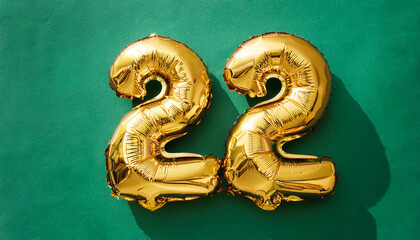 Banner with number 22 golden balloon on green backdrop. Birthday anniversary celebration.