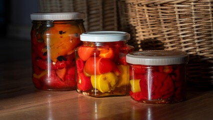 beautiful wicker baskets on the floor, homemade products in jars, canned tomatoes and peppers,...