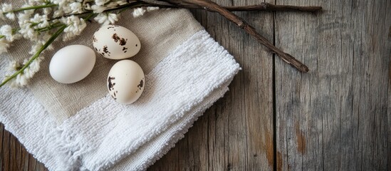 Fototapeta premium Quail eggs arranged on rustic wooden table with a cotton towel and willow branch enhancing natural farmhouse decor aesthetic
