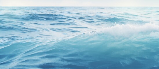 Fototapeta premium Gentle ocean waves with a tranquil blue hue creating a serene nature background for relaxation or meditation themes.