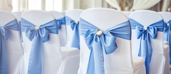 Elegant wedding chair decorations featuring white covers and blue bows in a beautifully designed restaurant interior setting.