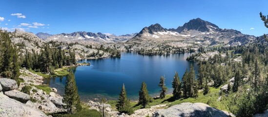 Serene mountain landscape featuring tranquil lakes surrounded by lush trees and majestic peaks under a clear blue sky.