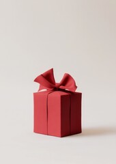 Fototapeta premium A red gift box tied with a shiny ribbon, placed against a soft beige background with gentle shadows.