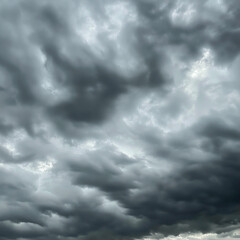 Obraz premium A dramatic sky with sun rays piercing through gaps in massive white clouds