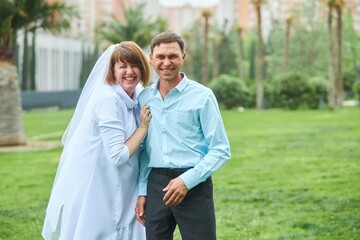 Obraz premium An adult bride and groom. Husband and wife's wedding anniversary photo shoot. We've been together for 30 years.