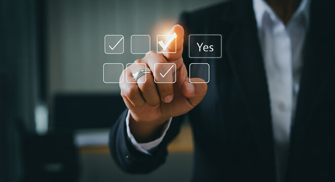 Using a Yes No Choice Checkbox to Make Selection s In a survey or professional setting, a hand choosing  Yes  from a computerized checkbox interface represents agreement, approval, or decision-making
