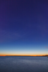 Full moon rising over the Baltic sea, sea shore view, late sunset time