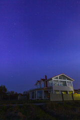Night clear sky view with starts and wooden house at foreground